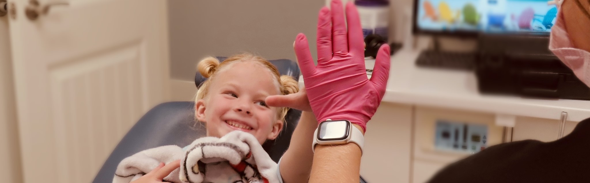 Young patient giving a high-five at Peak Pediatric Dentistry