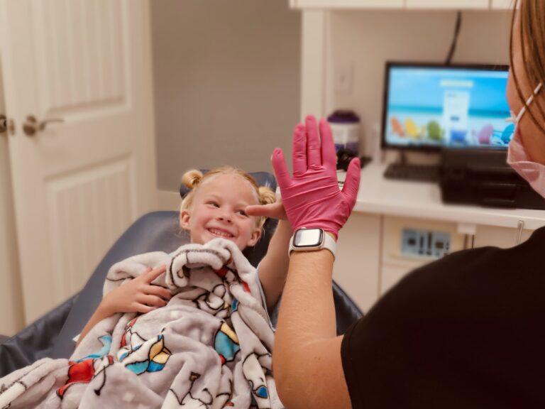 Young patient giving a high-five at Peak Pediatric Dentistry